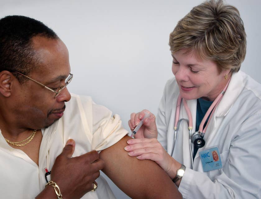 Registered nurse gives a patient a flu shot while giving instructions on aftercare