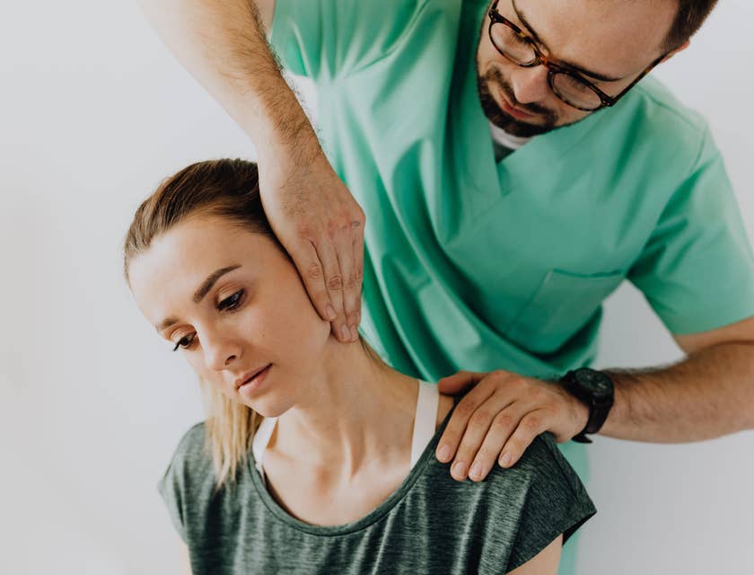Rehab technician conducts initial screening by assessing the neck pain of the patient