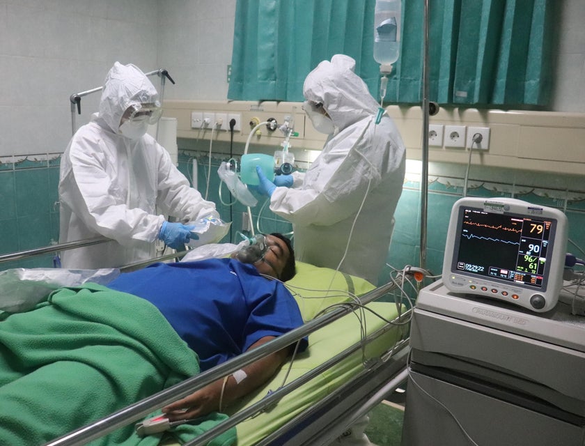 Respiratory Care Practitioner monitors a patient's condition with a colleague in a protective suit