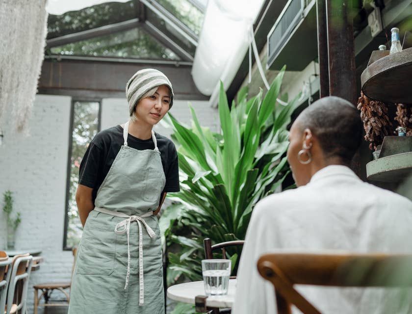 A female restaurant manager talking to a staff member.