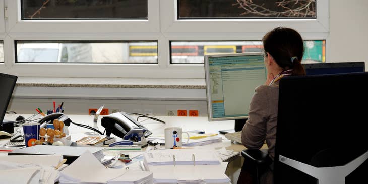 Revenue cycle manager checks emails while preparing billing documents for the meeting