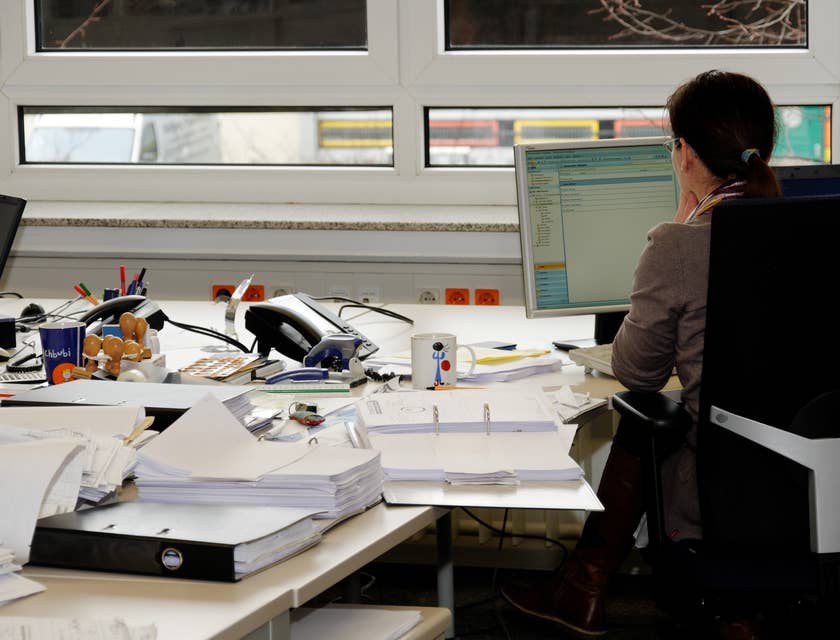Revenue cycle manager checks emails while preparing billing documents for the meeting