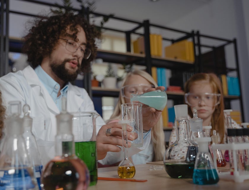 STEM teacher shows students how to transfer chemical solution to a flask