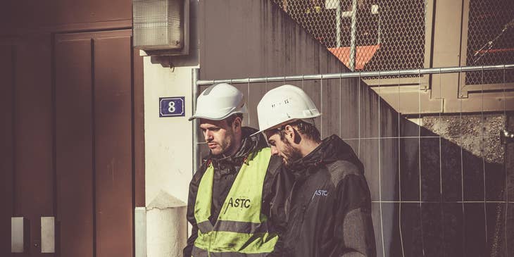 Safety manager talks with a worker to discuss health protocols in a workplace.