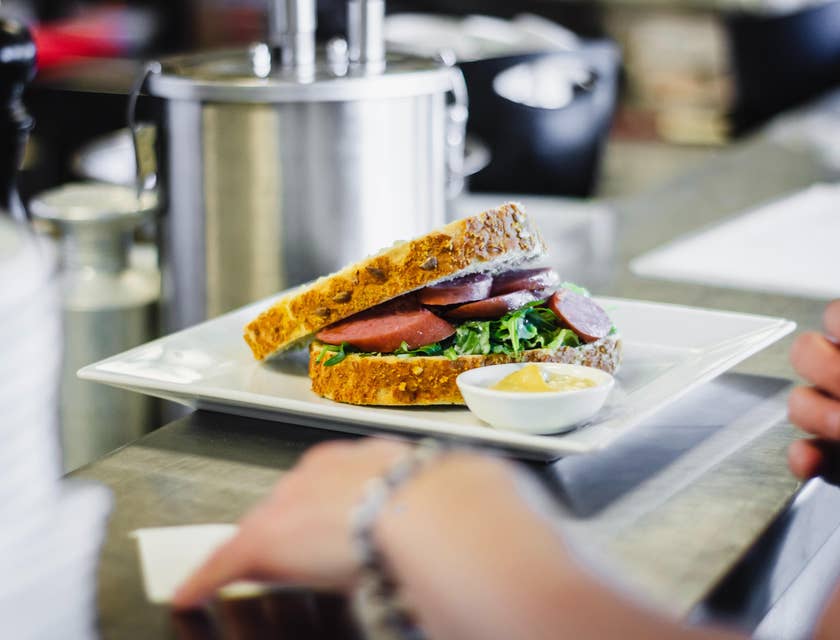 Sandwich artist preparing sandwich in a deli.