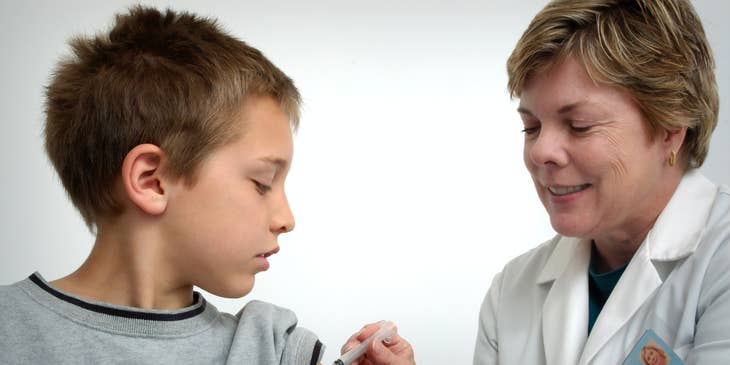 School nurse gives a vaccine shot to a student in the school clinic