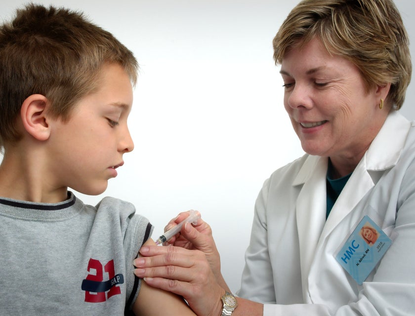 School nurse gives a vaccine shot to a student in the school clinic