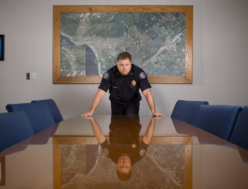 Security officer in a black uniform standing behind a conference table