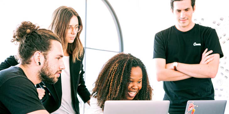 A software development team meeting behind two laptop computers