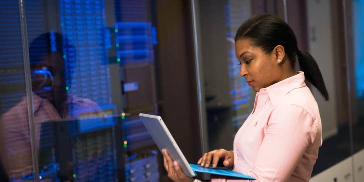 Solutions Engineer checks system hardware while checking her laptop for a software upgrade