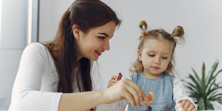 Speech language pathologist helping a toddler identify animals during a therapy session