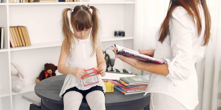 Speech pathologist asses if she can read aloud colors during their therapy session