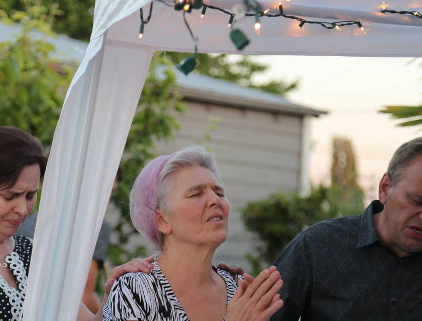 Spiritual healer prays with a woman during a healing service