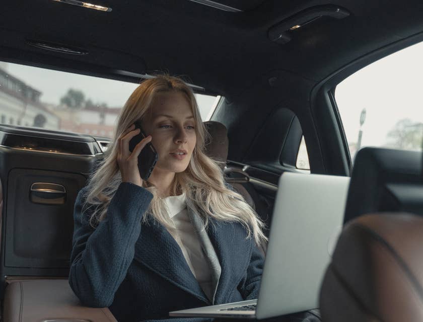 Strategic sourcing analyst riding on a car on her way to suppliers while on the phone