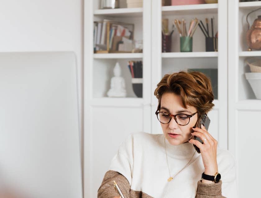 Strategic sourcing manager calls her team to provide cost estimates of a new business venture while listing on a paper.