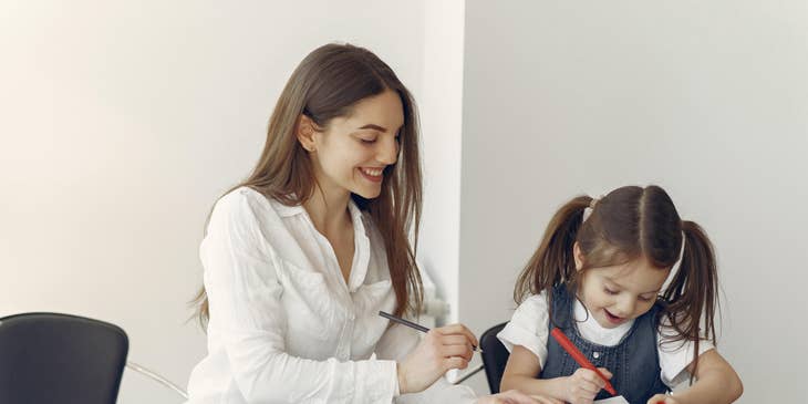 Therapeutic support staff praise patient as she watches patient draw and color happily
