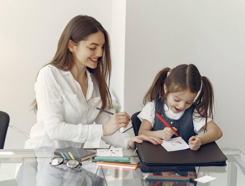 Therapeutic Support Staff praise patient as she watches patient draw and color happily