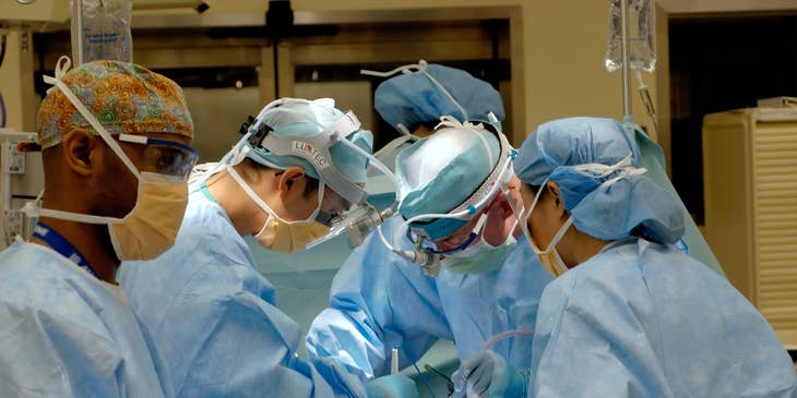 Thoracic surgeon assists other surgeons in a heart transplant procedure