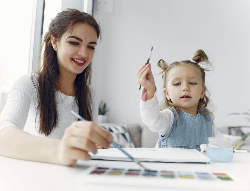 Toddler Teacher shows a toddler student how to use watercolor