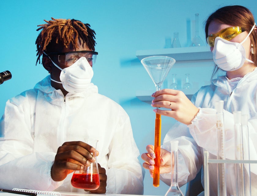 Toxicologist studies new toxin specimen and its effect in a laboratory with a colleague in a protective suit