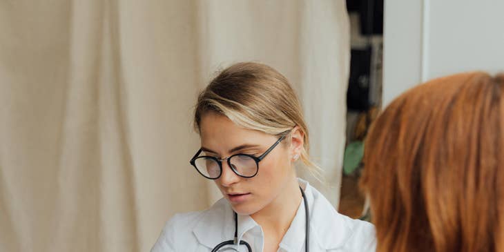 Urgent care nurse documents patient's information while performing a physical examination