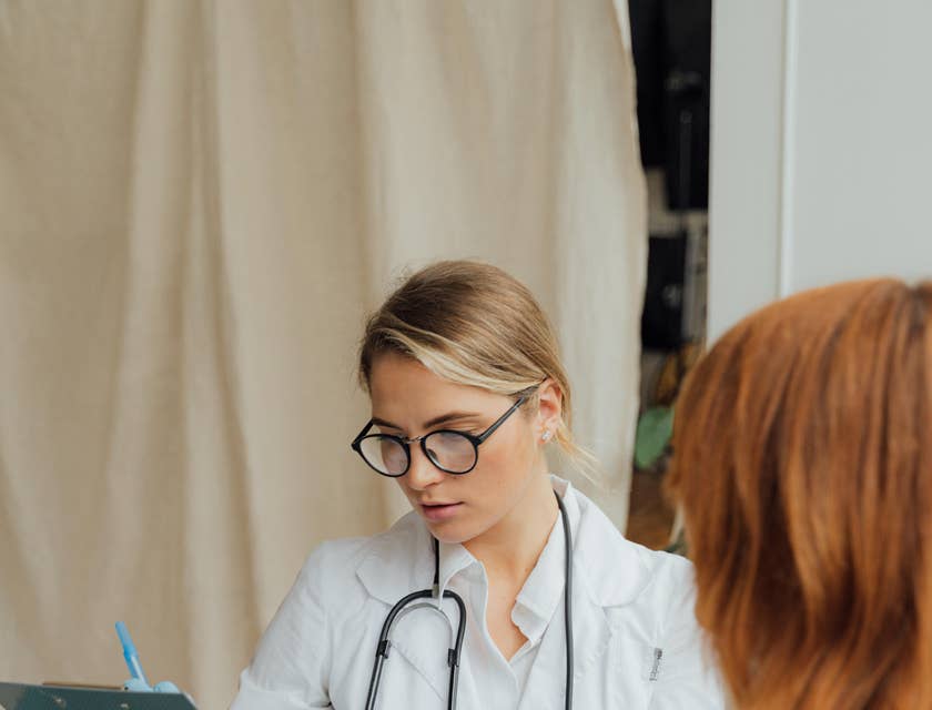Urgent care nurse documents patient's information while performing a physical examination
