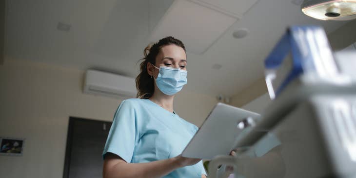 Vascular technologist reviewing patient's information before doing ultrasound procedure