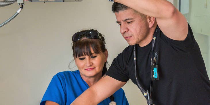 X-ray technician positioning the wrist of the patient.