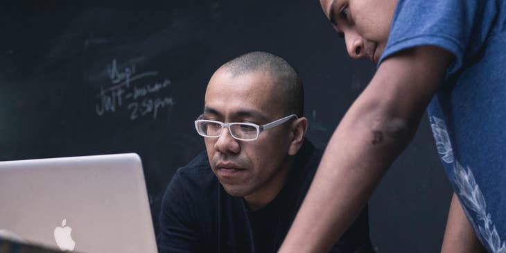 Academic Advisor discussing academic goals with a student while looking at a laptop