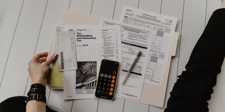 Accounting Clerk holding a document near pen and calculator