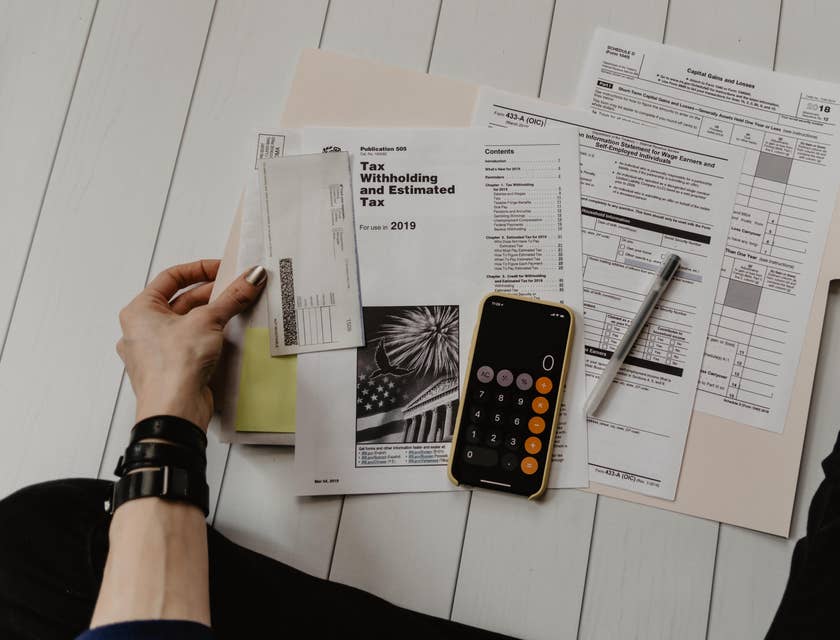 Accounting Clerk holding a document near pen and calculator