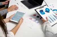 Un actuario usando una camisa de manga larga presenta gráficos de datos al equipo.