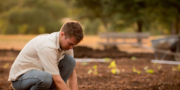 Agronomist crouching on the ground and collecting soil samples