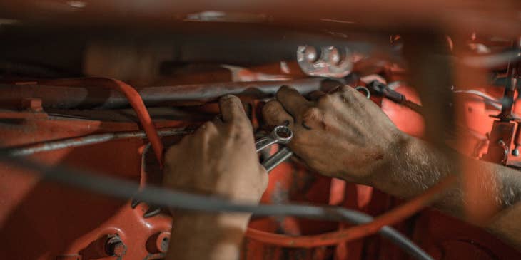 Aircraft Mechanic holding a red motor frame and wrenches in both hands