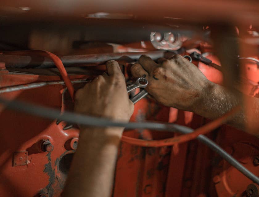 Aircraft Mechanic holding a red motor frame and wrenches in both hands