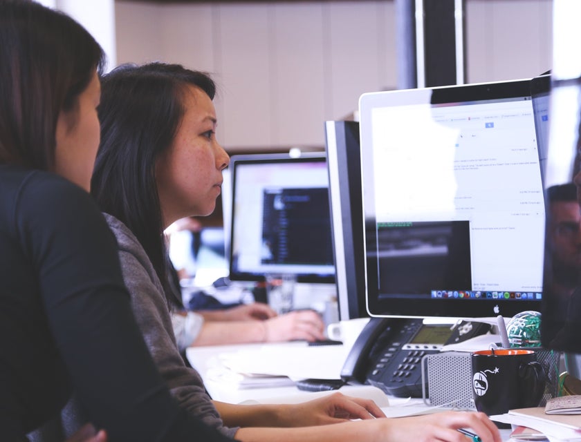 Application Architect sitting beside her colleague while checking on the initial stages of the software project