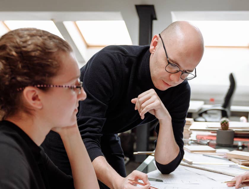 Architectural Drafter checks the drawing done by his teammate for a client presentation