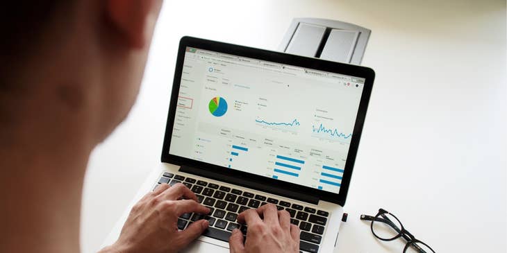 Asset Manager checking on some graphs on a Macbook