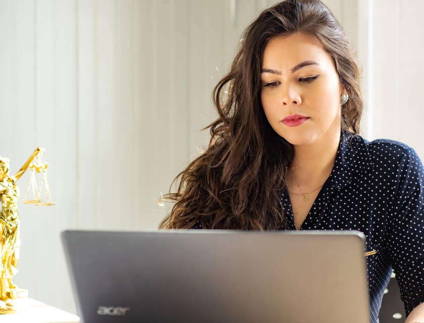 A Female Associate Attorney sitting in front of her laptop working on reports.