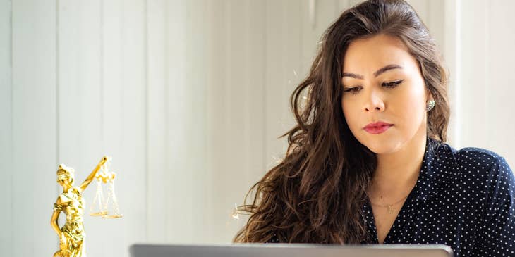 A Female Associate Attorney sitting in front of her laptop working on reports.