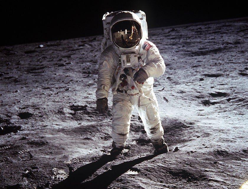 Astronomers on the moon gathering sample rocks to be sent back to earth.