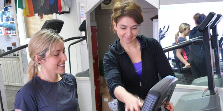 Athletic Trainer next to a woman in a cycling machine.