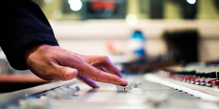 Audio Technician adjusting the dial of the mixer in preparation for the recording session