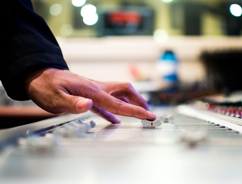 Audio Technician adjusting the dial of the mixer in preparation for the recording session