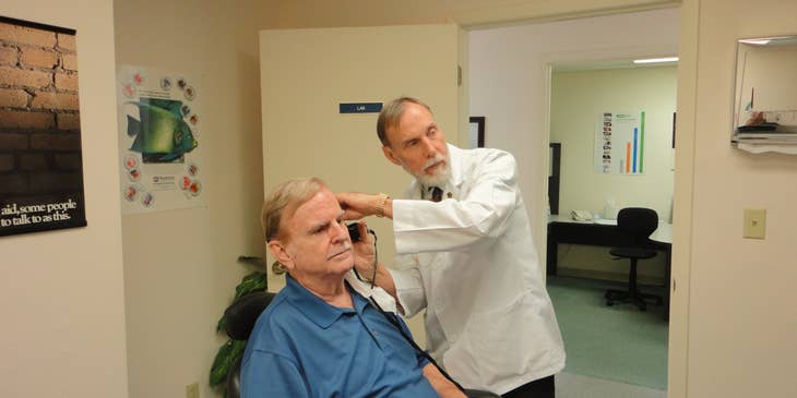 Audiologist conducting auditory test on patient.