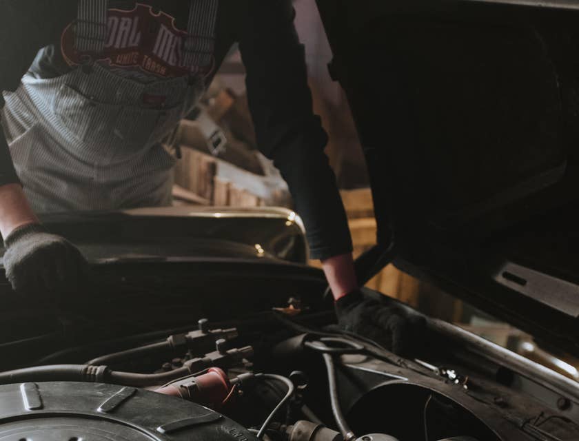 Auto Electrician checking under the hood of a vehicle