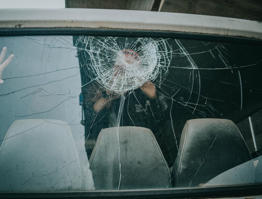 Auto Glass Technician checking a cracked rear window of a car