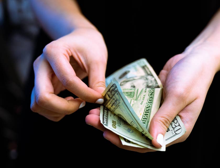 Bank Teller counting twenty dollar bills.