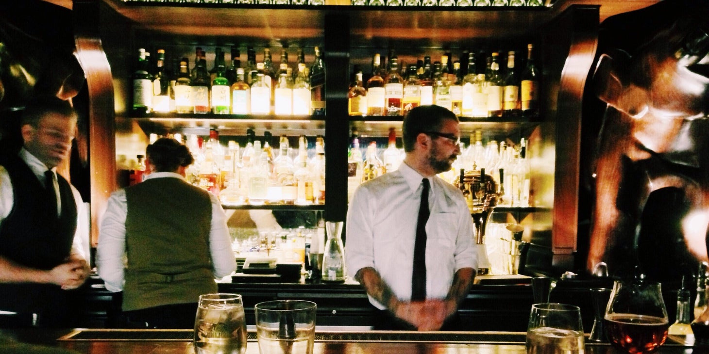 Bar manager overseeing staff on a busy night.