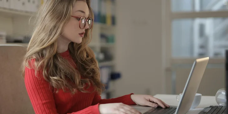 A focused woman working on a laptop.